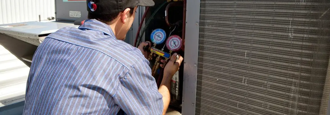 HVAC technician servicing a condenser unit in Conway