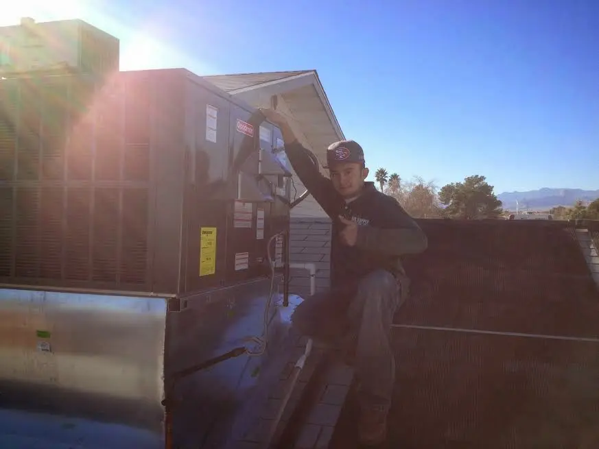 HVAC technician performing Heat Pump Repair on a rooftop unit in Conway